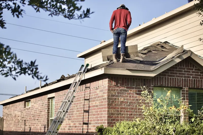 Professional roofer working on a residential roof in Bethel